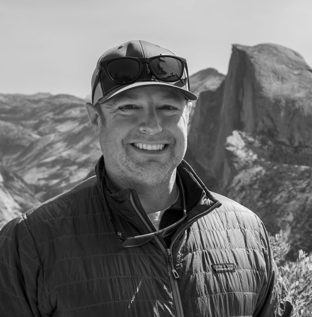 Picture of Brian Byrd, PhD, standing in front of a mountain landscape.
